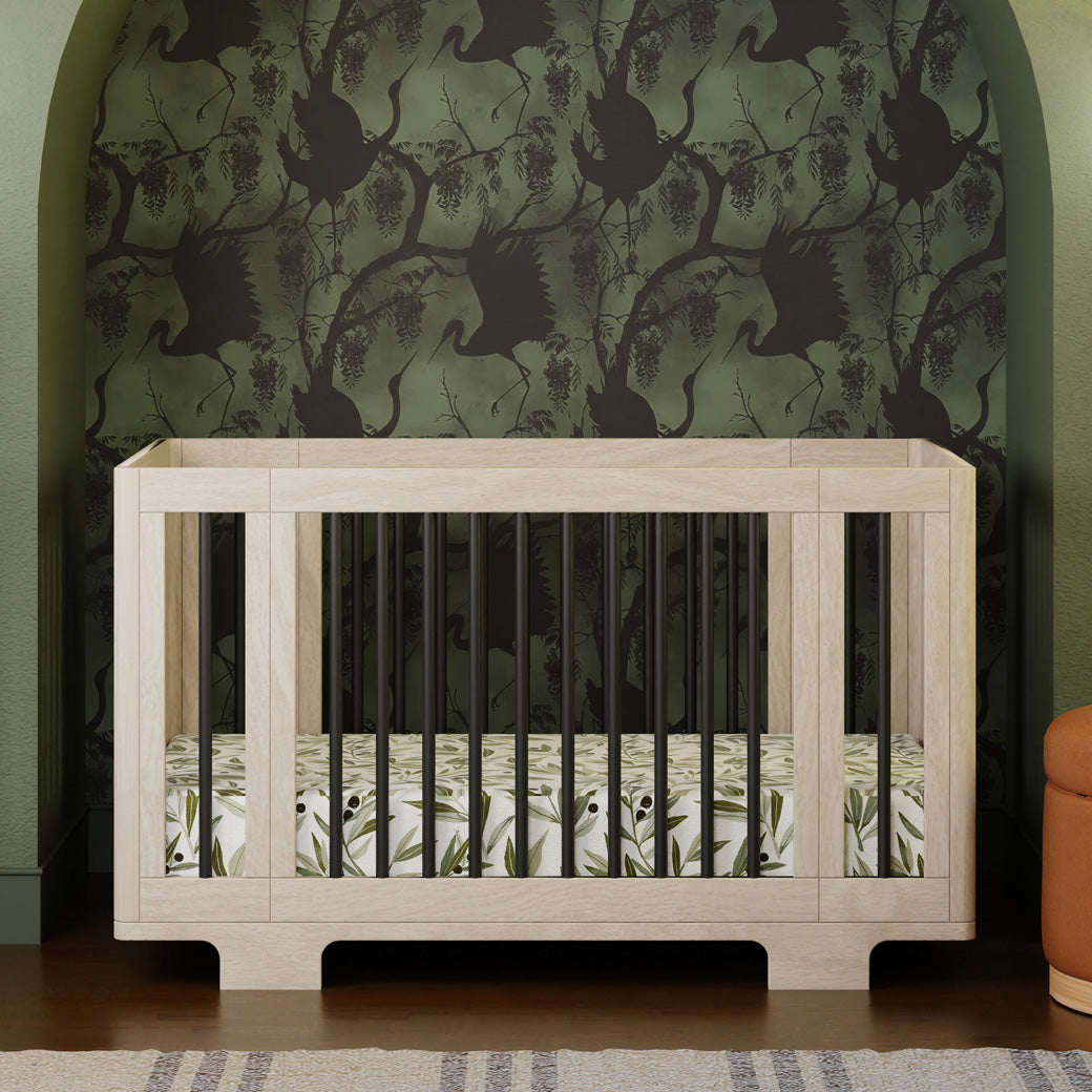 Front view of Babyletto's Yuzu 8-In-1 Convertible Crib With All Stages Conversion Kits with green wallpapers in -- Color_Washed Natural / Black