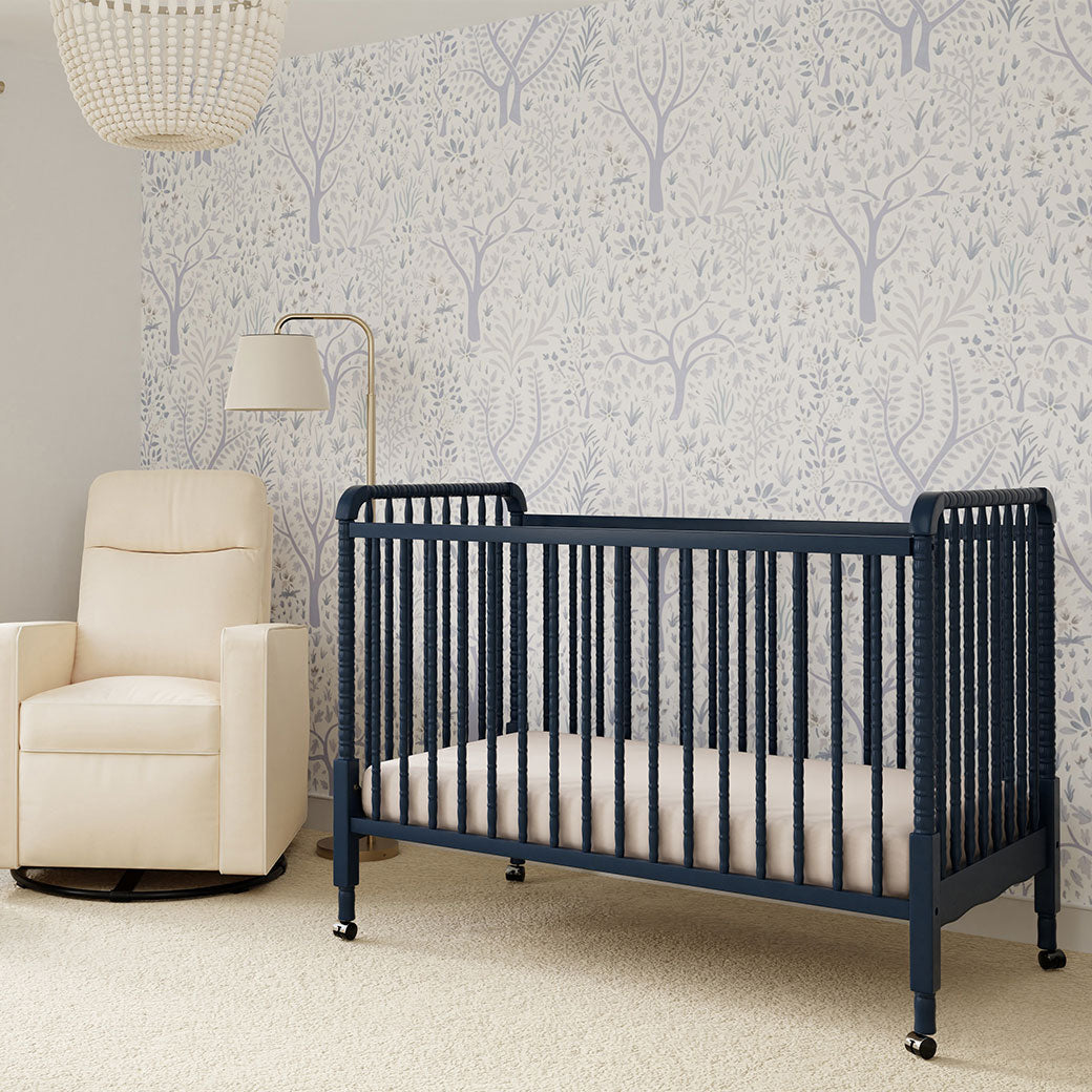 DaVinci’s Jenny Lind Crib next to a recliner in -- Color_Navy