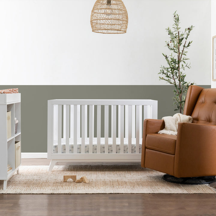 DaVinci Otto 3-in-1 Convertible Crib next to a recliner  in -- Color_White _ Wood