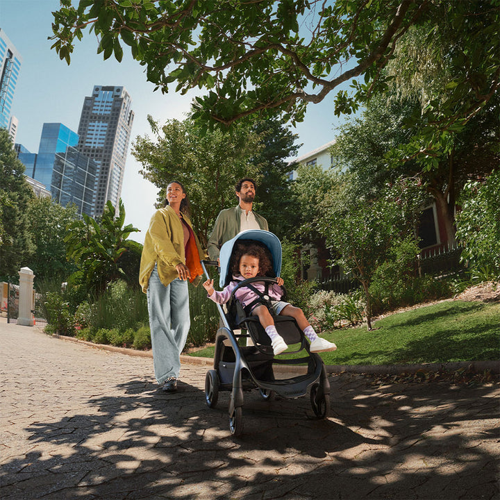 Mom and dad pushing their child in the Bugaboo Dragonfly Stroller in -- Color_Skyline Blue