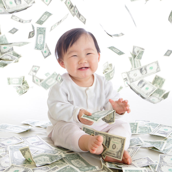 smiling baby surrounded by falling dollar bills