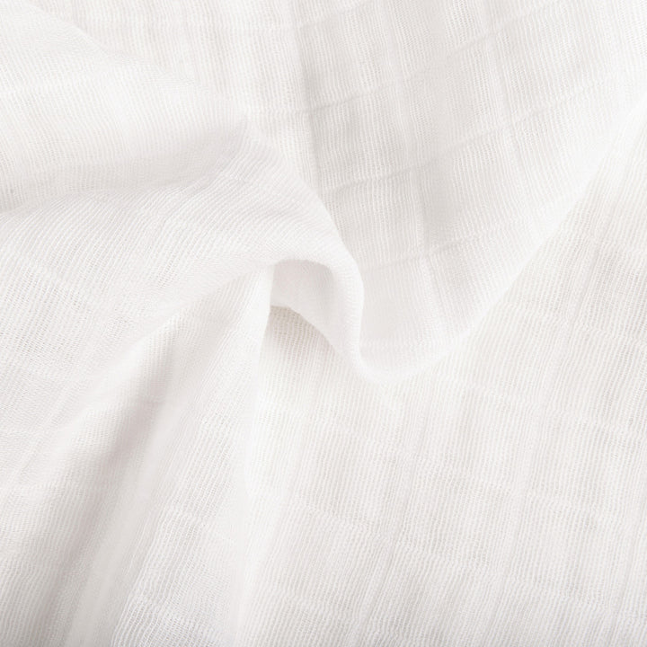 Ruffled closeup of material of Babyletto's All-Stages Midi Crib Sheet In GOTS Certified Organic Muslin Cotton in -- Color_White